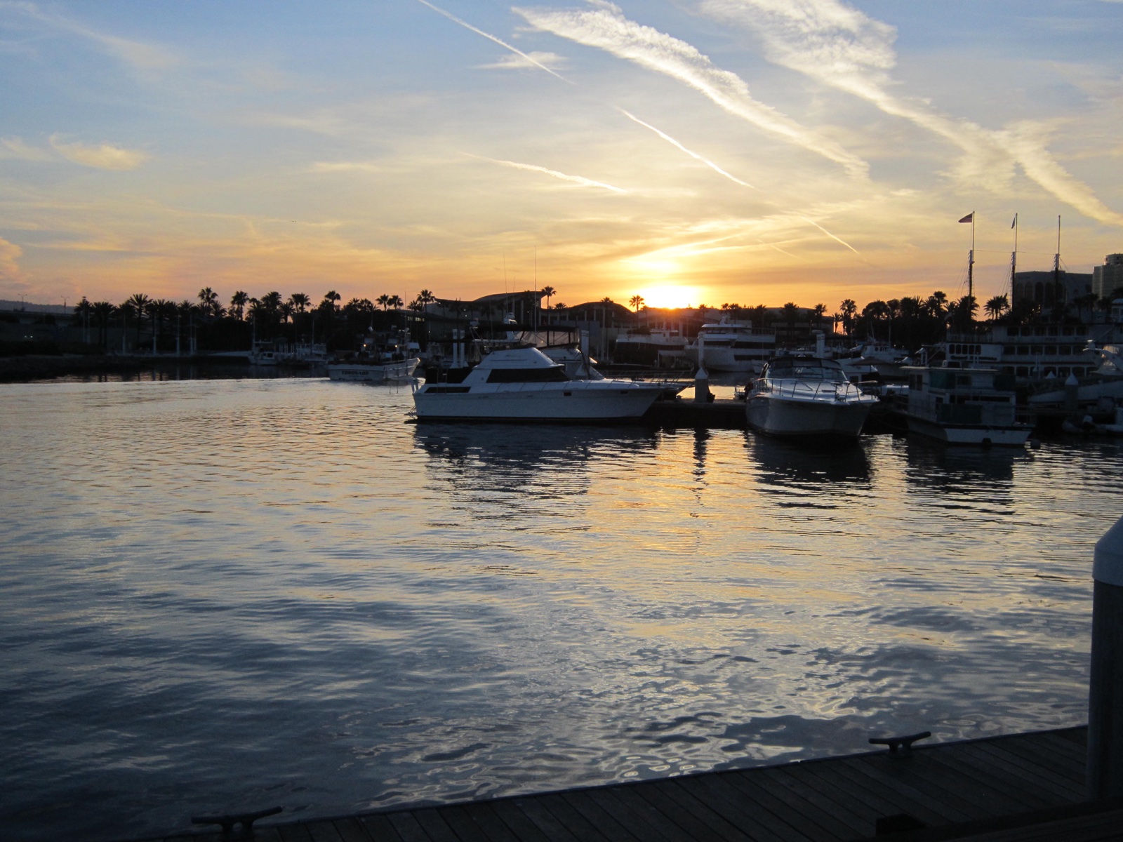 Sunset over the downtown Long Beach waterfront docks, with yachts silhouetted on glassy water